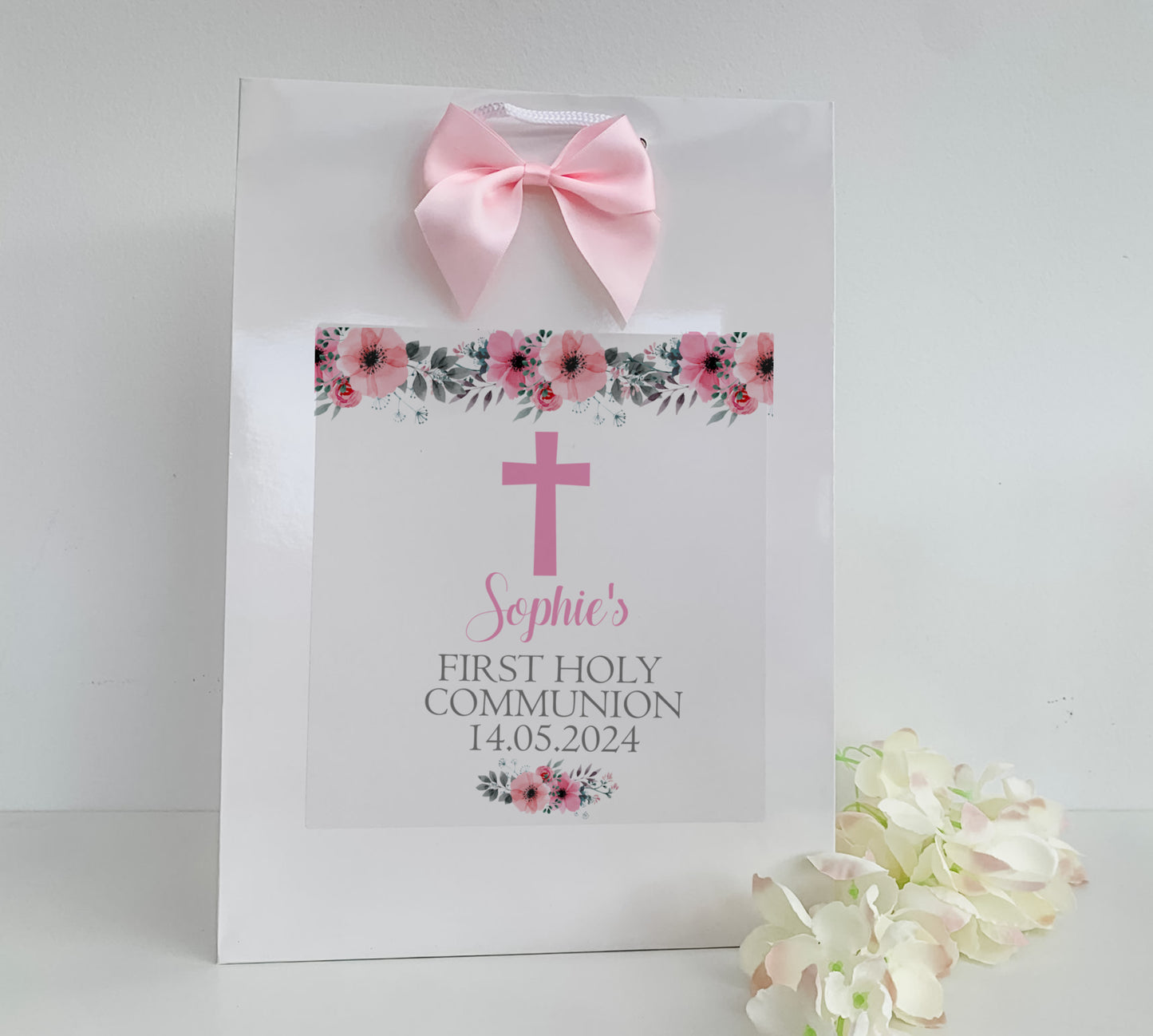a white paper bag with a pink cross on it
