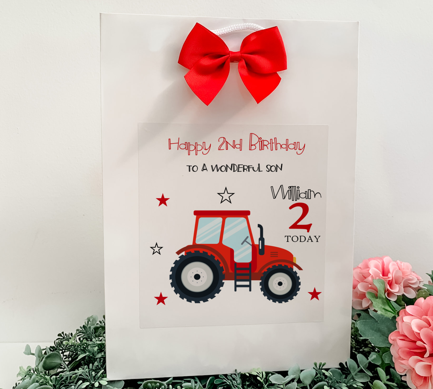 a birthday card with a tractor and a red bow