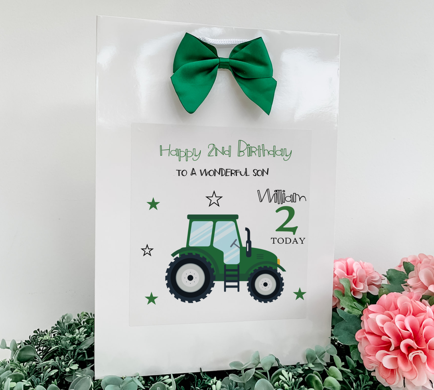 a birthday card with a tractor and a green bow