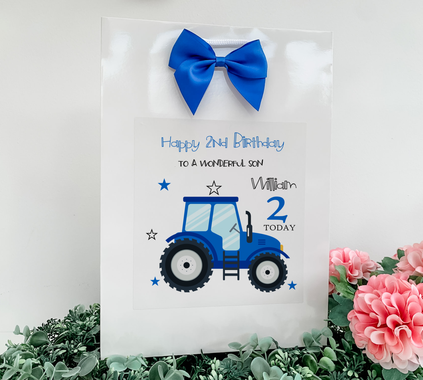 a birthday card with a tractor and a blue bow