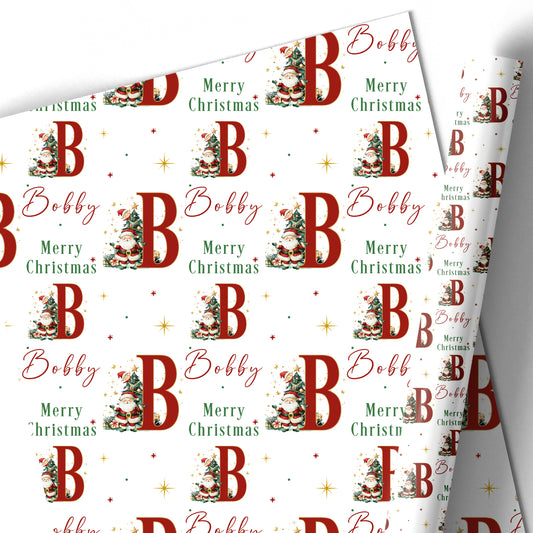 Personalised Christmas wrapping paper featuring Santa Claus, Christmas tree, large initial and name in red, green, gold and white festive design.