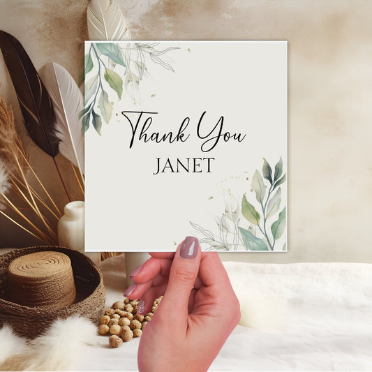 a person holding a card with a thank you written on it