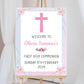 a welcome sign with a pink cross on it