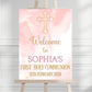 a pink and gold welcome sign on a easel