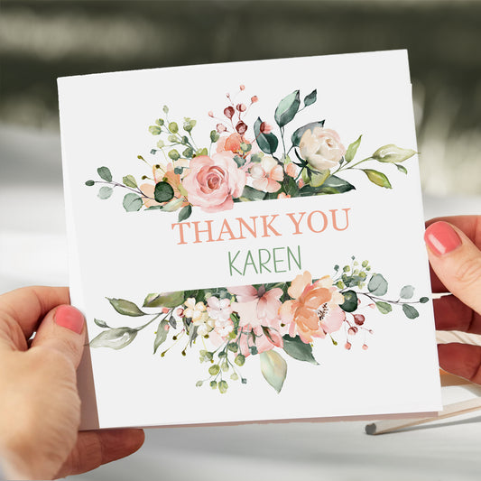 a person holding a thank card with flowers on it