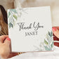 a person holding a card that says thank you