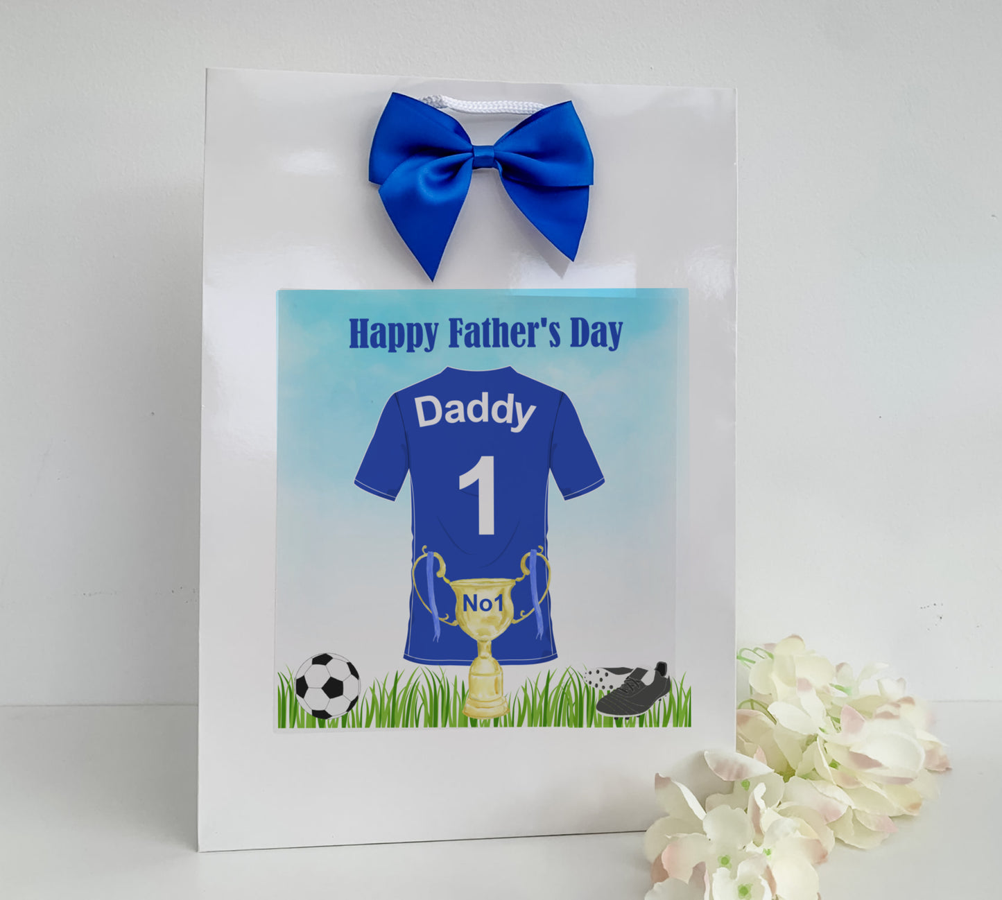 a father's day card with a soccer jersey and a blue bow