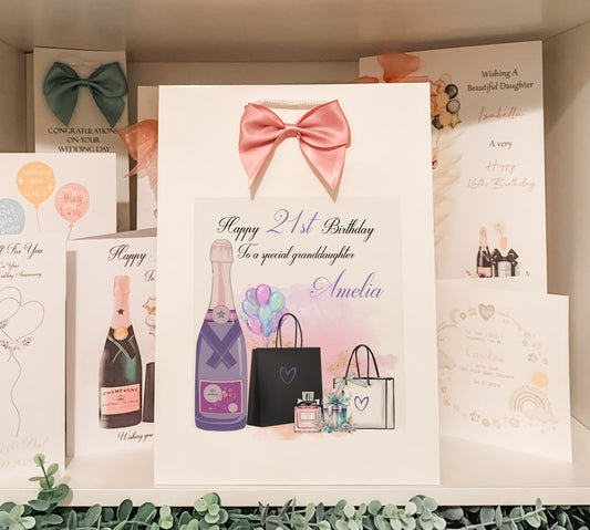 a birthday card with a pink bow and a bottle of champagne