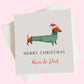 a christmas card with a dachshund wearing a santa hat
