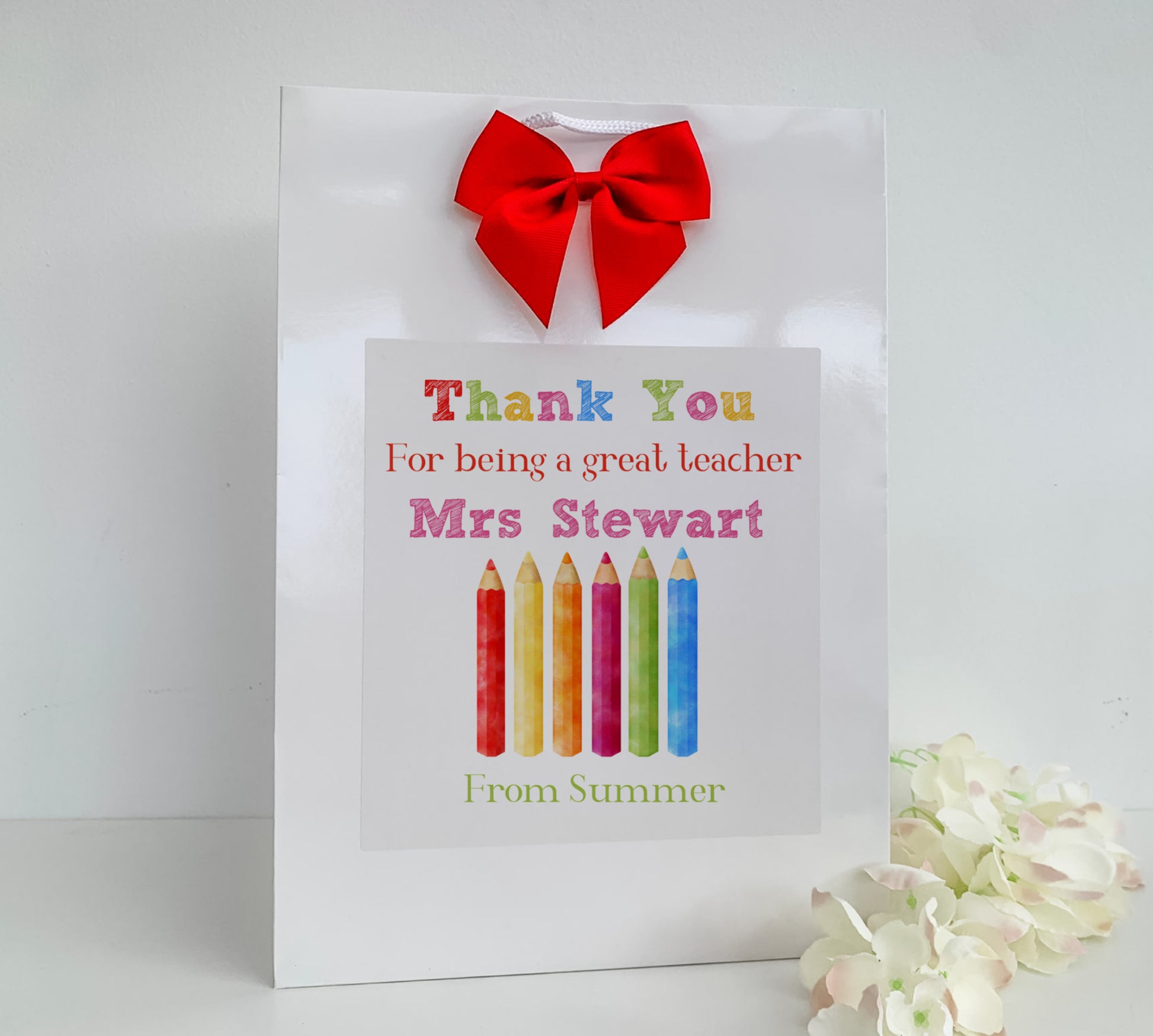 a thank you card with a red bow on top of it