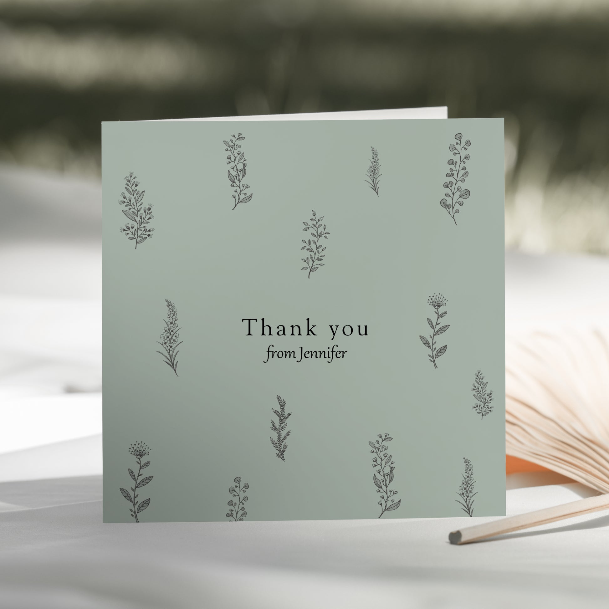 a thank you card sitting next to an open book