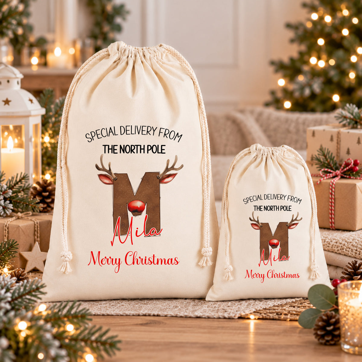 Two white drawstring bags with Christmas-themed designs and text, placed on a wooden surface with pine cones and other holiday decorations in the background.