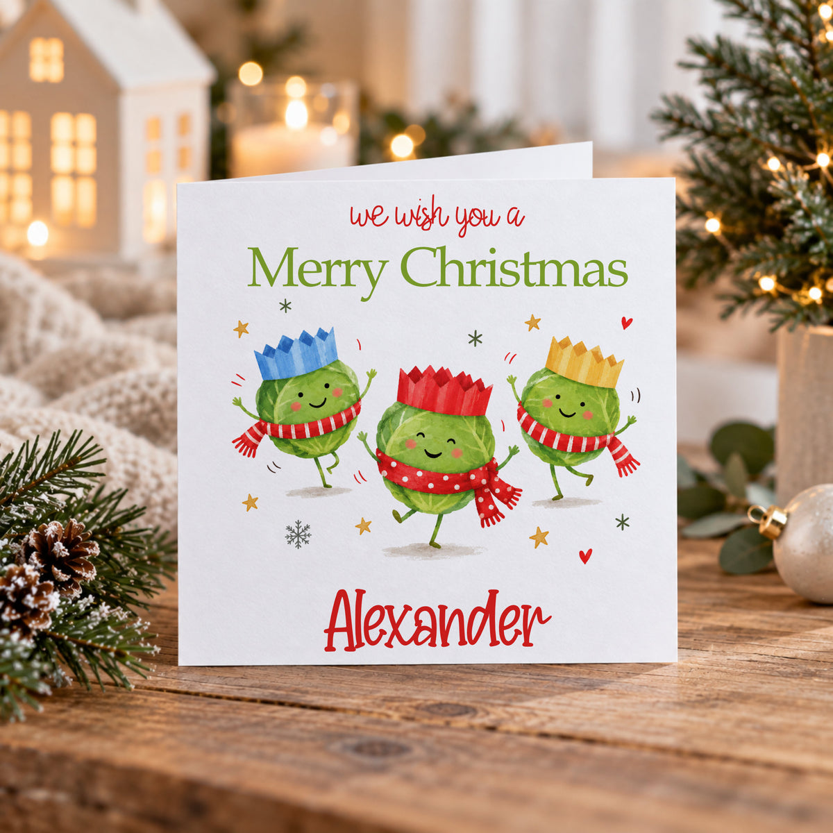 Personalised Christmas card featuring three cute Christmas sprouts wearing colourful crowns and scarves with Merry Christmas and Alexander text, but you change change to any text you wish