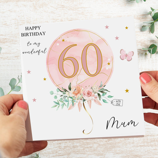a woman holding a birthday card with the number 60 on it