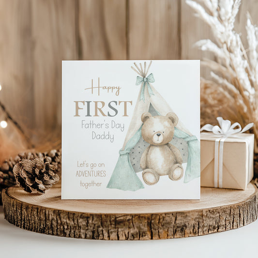 A greeting card with a teddy bear and a teepee tent design, celebrating Father's Day. The card has a message that reads "Happy FIRST Father's Day Daddy" and "Let's go on adventures together".