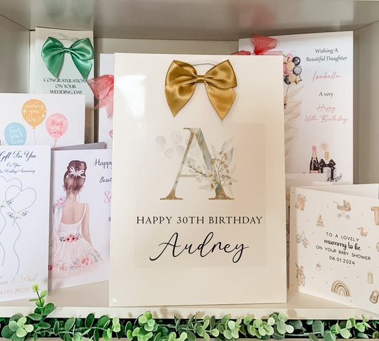a birthday card with a gold bow on it