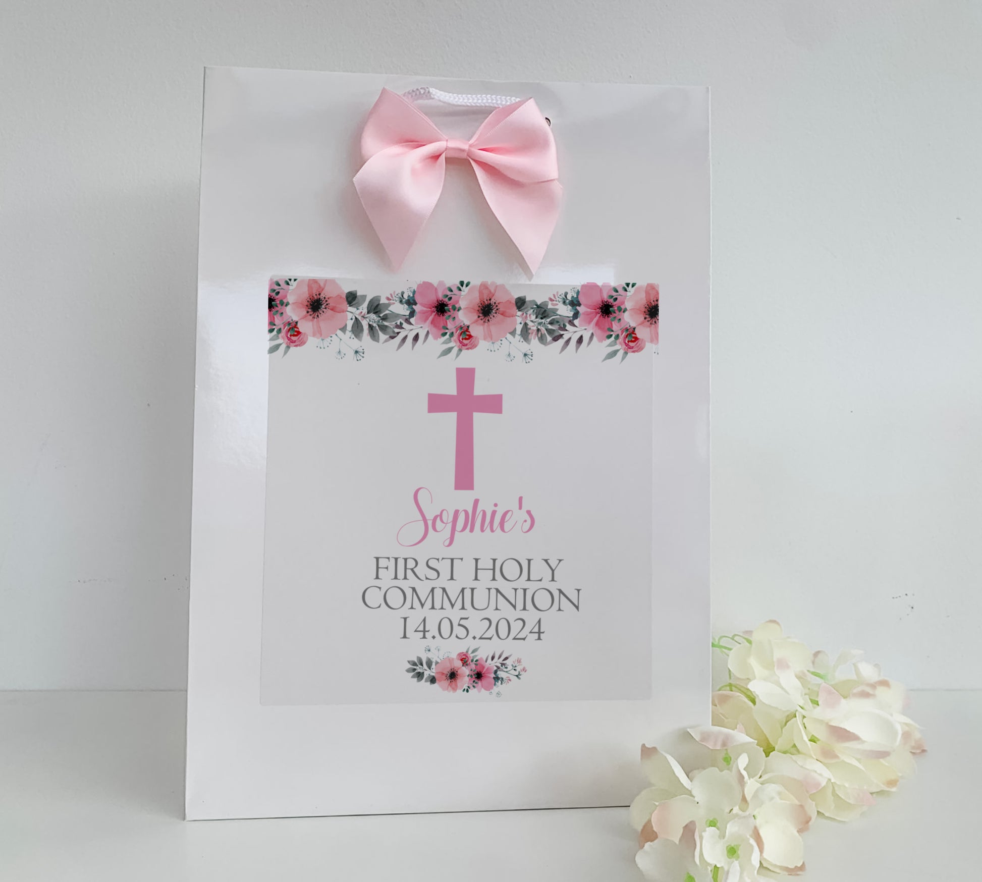 a white paper bag with a pink cross on it