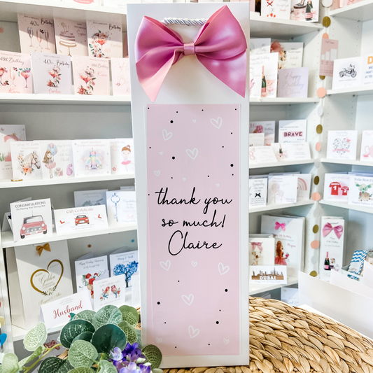 a card with a pink bow on top of a table