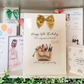 a birthday card with a gold bow on it