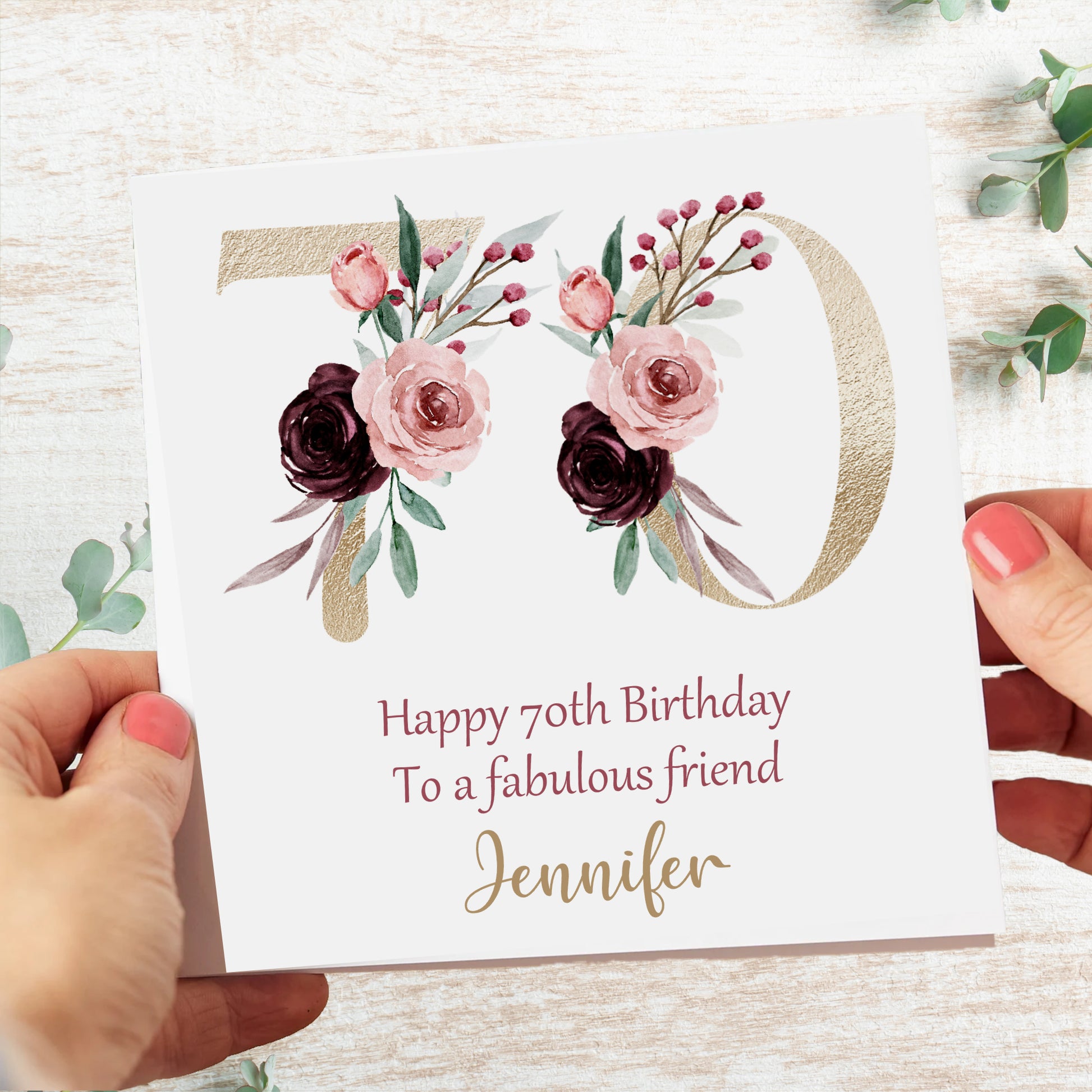 a woman holding a birthday card with flowers on it