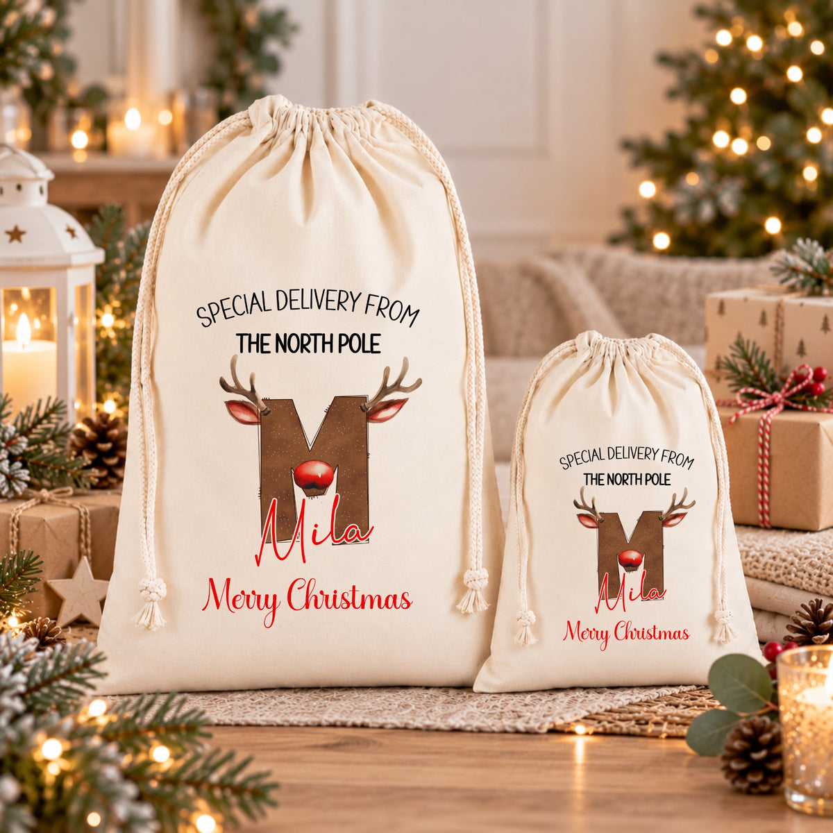 Two white drawstring bags with Christmas-themed designs and text, placed on a wooden surface with Christmas decorations and lights in the background.