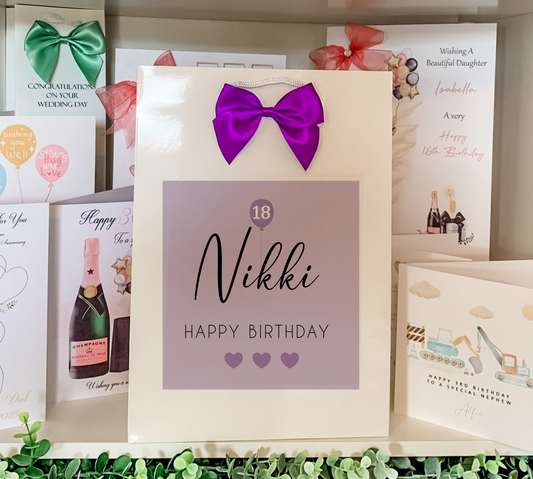 a birthday card with a purple bow on it