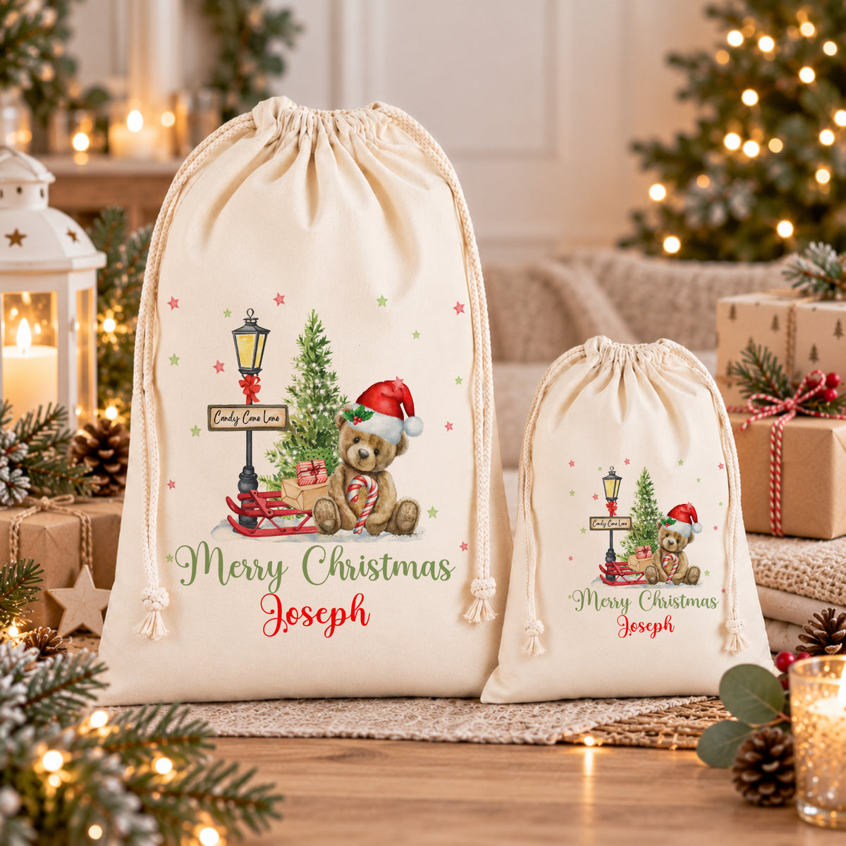two white drawstring bags with Christmas-themed designs, including a teddy bear and a Christmas tree, placed on a wooden surface.