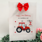 a birthday card with a tractor and a red bow