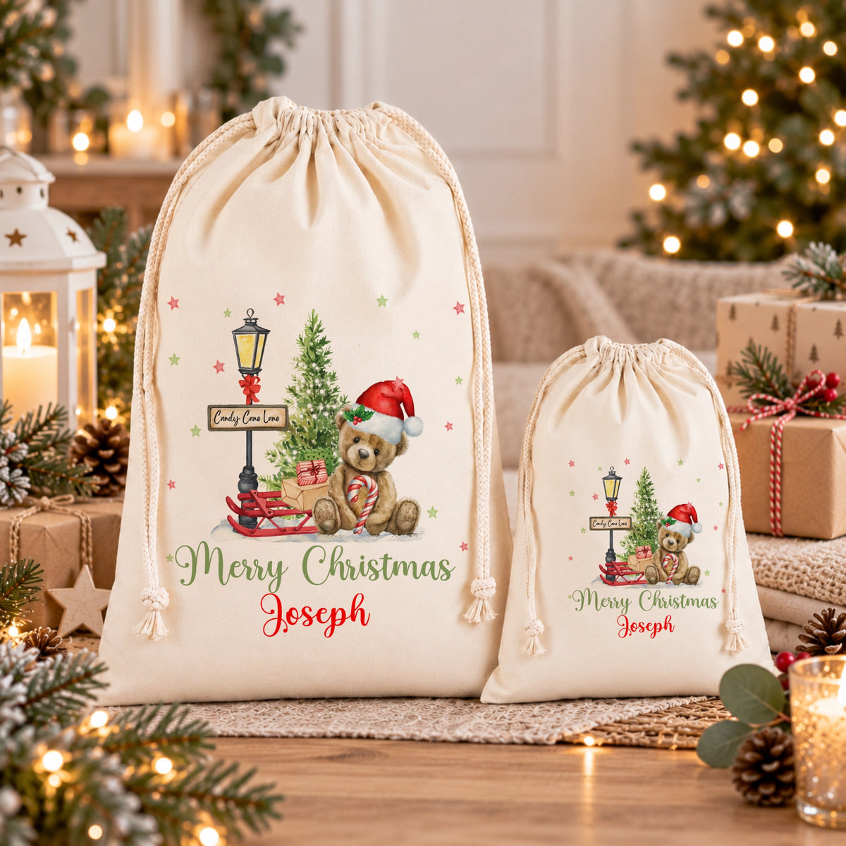 two white drawstring bags with Christmas-themed designs, including a teddy bear and a Christmas tree, placed on a wooden surface.