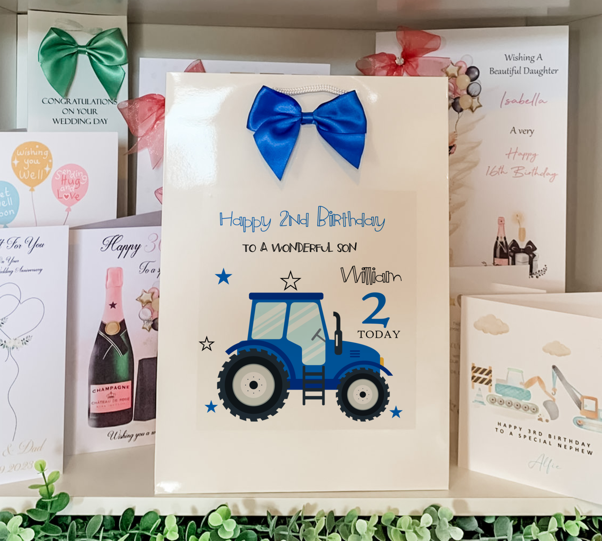 a birthday card with a tractor and a blue bow