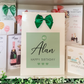 a birthday card with a green bow on it