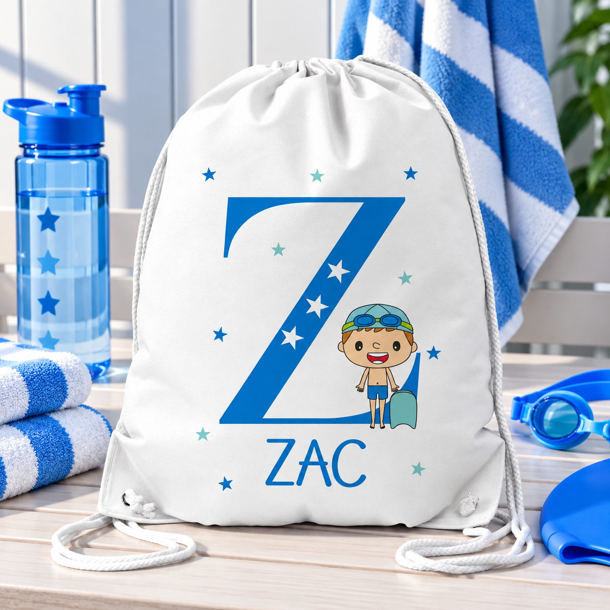 White personalised drawstring swimming bag for kids, featuring a fun blue swimmer design with a large initial and name. Perfect for swimming lessons, leisure swimming, holidays and keeping swimwear and essentials together.