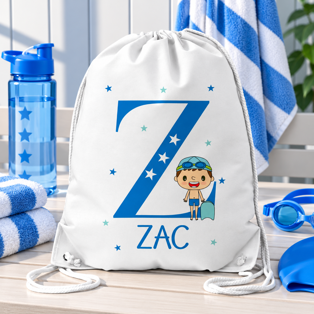 White personalised drawstring swimming bag for kids, featuring a fun blue swimmer design with a large initial and name. Perfect for swimming lessons, leisure swimming, holidays and keeping swimwear and essentials together.