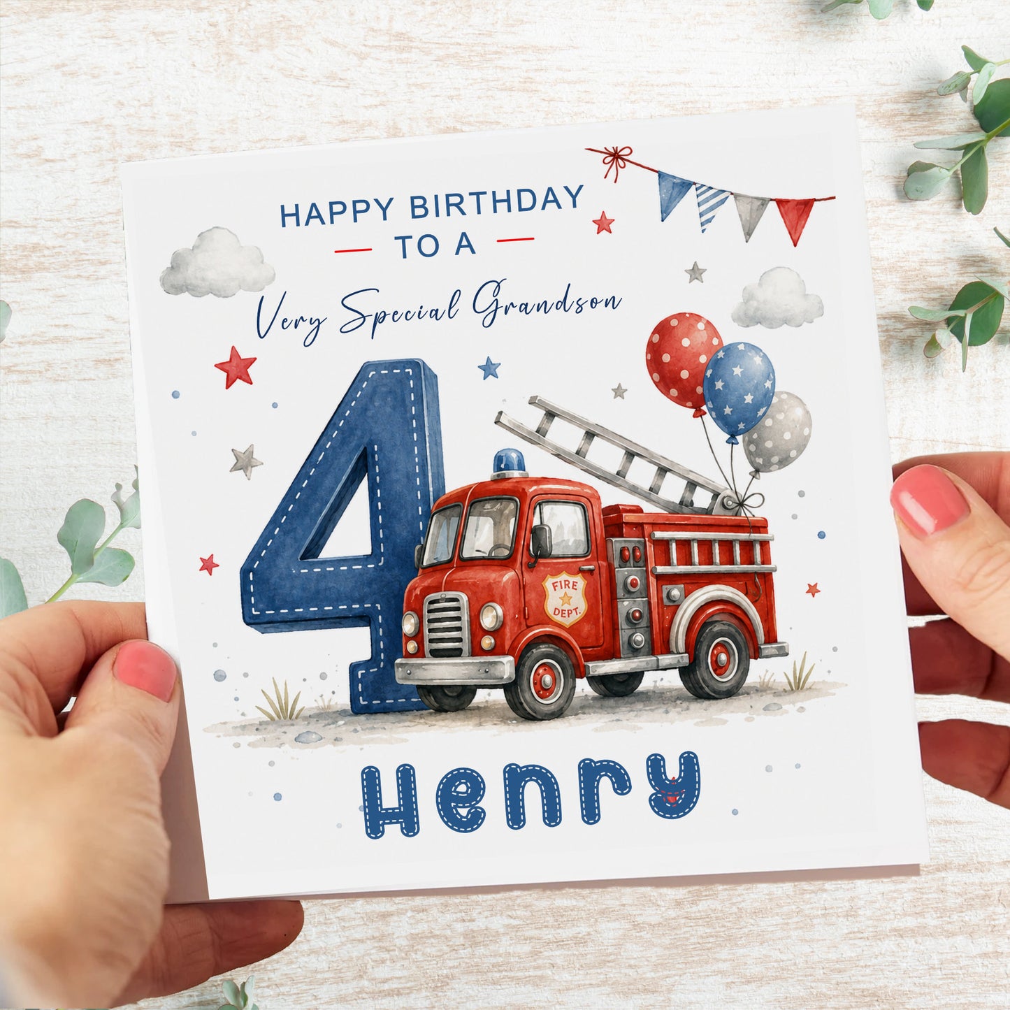 A personalized birthday card for a grandson, held by two hands. The card features a red fire truck, a large blue number 4, balloons, and the text 'HAPPY BIRTHDAY TO A Very Special Grandson' and 'Henry'.