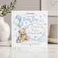 A personalized baby boy birth announcement card featuring a teddy bear, balloons, and stars in blue and white, styled on a marble surface with a vase and decor in the background.