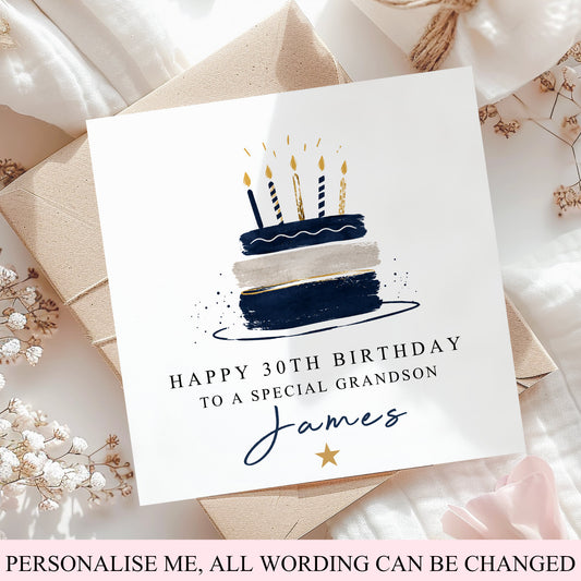 A square birthday card with a navy and cream cake illustration and the text 'HAPPY 30TH BIRTHDAY TO A SPECIAL GRANDSON James' is displayed on top of kraft paper envelopes and white fabric with dried flowers. A pink banner at the bottom reads 'PERSONALISE ME, ALL WORDING CAN BE CHANGED'.