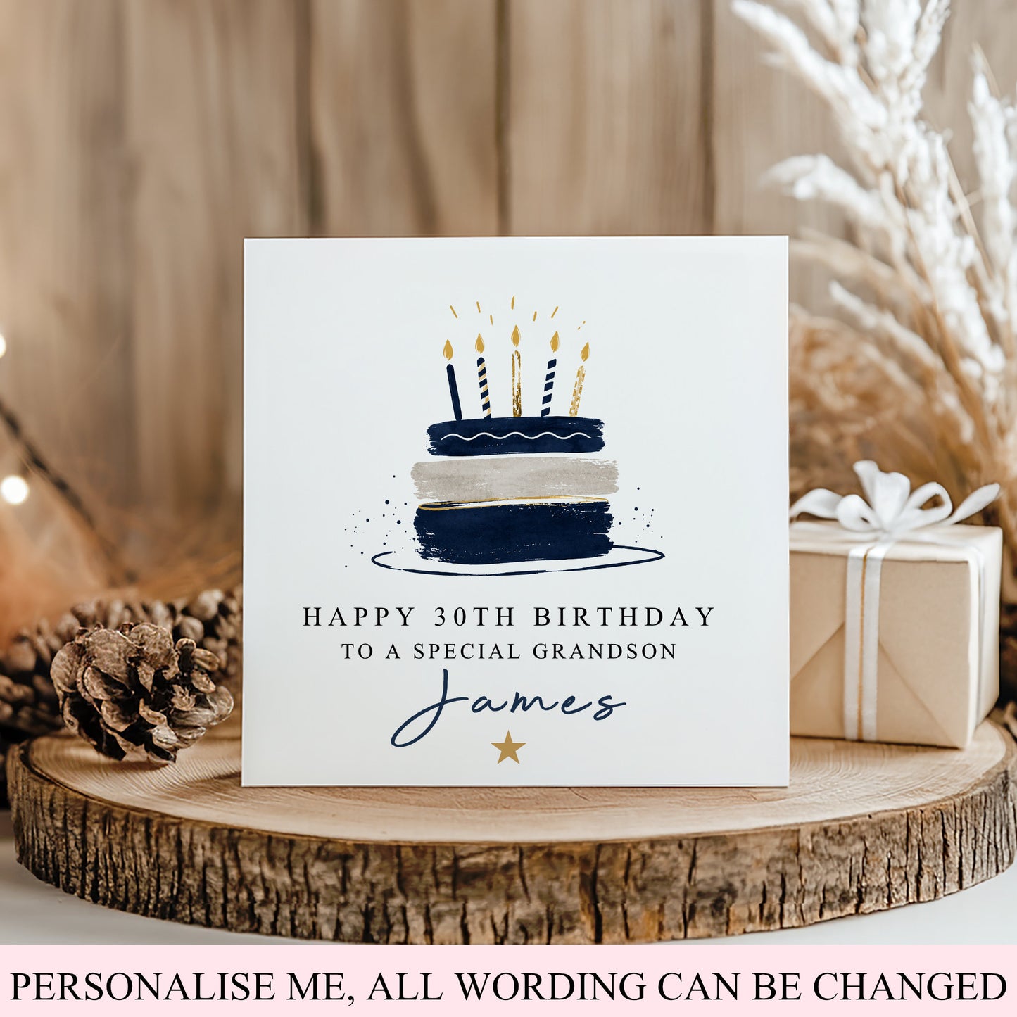A square birthday card with a navy and cream cake illustration and the text 'HAPPY 30TH BIRTHDAY TO A SPECIAL GRANDSON James' displayed on a rustic wood slice with a gift box and dried grass in the background.