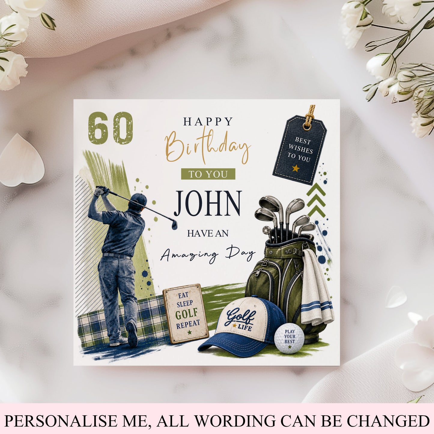 A custom golf-themed 60th birthday card shown flat on a light marble surface with decorative flowers. The card features illustrated golf equipment, a golfer, and customizable text including 'HAPPY Birthday TO YOU JOHN HAVE AN Amazing Day' and 'PERSONALISE ME, ALL WORDING CAN BE CHANGED' at the bottom.