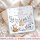 A personalized baby boy's first birthday card styled on top of kraft paper envelopes and white fabric. The card features watercolor illustrations of baby clothing, a teddy bear, and a baby carriage, with the text 'Welcome to the World Joshua Patrick Smith 14 August 2026'.