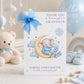 A white new baby grandson greeting card displayed upright in a soft blue and neutral nursery setting. The card features a sleeping baby elephant dressed in blue, resting on a golden crescent moon and surrounded by blue clouds, stars, hearts and delicate blue and cream flowers. The card reads “Thank You for the Precious Gift of Our Grandson” and includes personalised birth details for Samuel James Barton, followed by the message “He Will Be So Loved and Cherished.”
