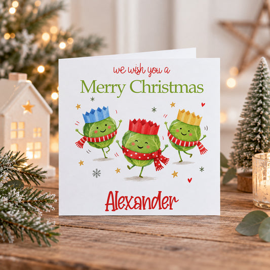 Personalised Christmas card featuring three cute Christmas sprouts wearing colourful crowns and scarves with Merry Christmas and Alexander text, but you change change to any text you wish