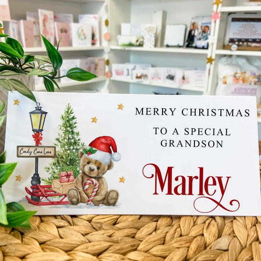 Christmas card with a teddy bear and tree on a white background, featuring text 'Merry Christmas to a special grandson Marley'.