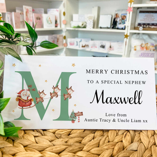 Personalized Christmas card for a nephew with Santa and reindeer design, placed on a woven surface.