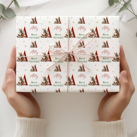 Personalised Christmas wrapping paper featuring Santa Claus, Christmas tree, large initial and name in red, green, gold and white festive design.