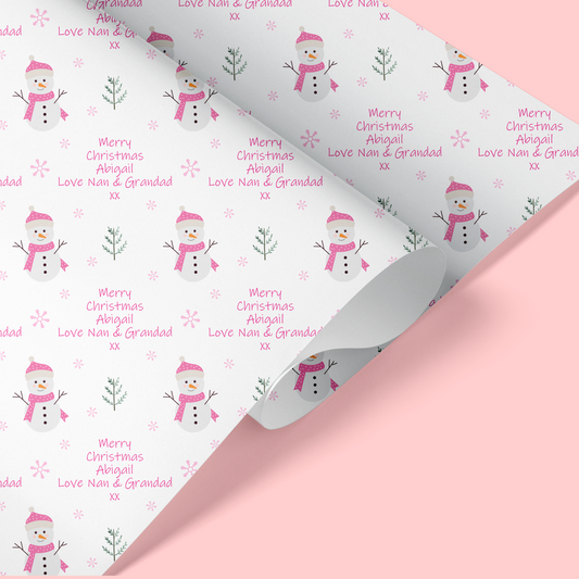 christmas wrapping paper with pink snowman design and snowflakes in the background