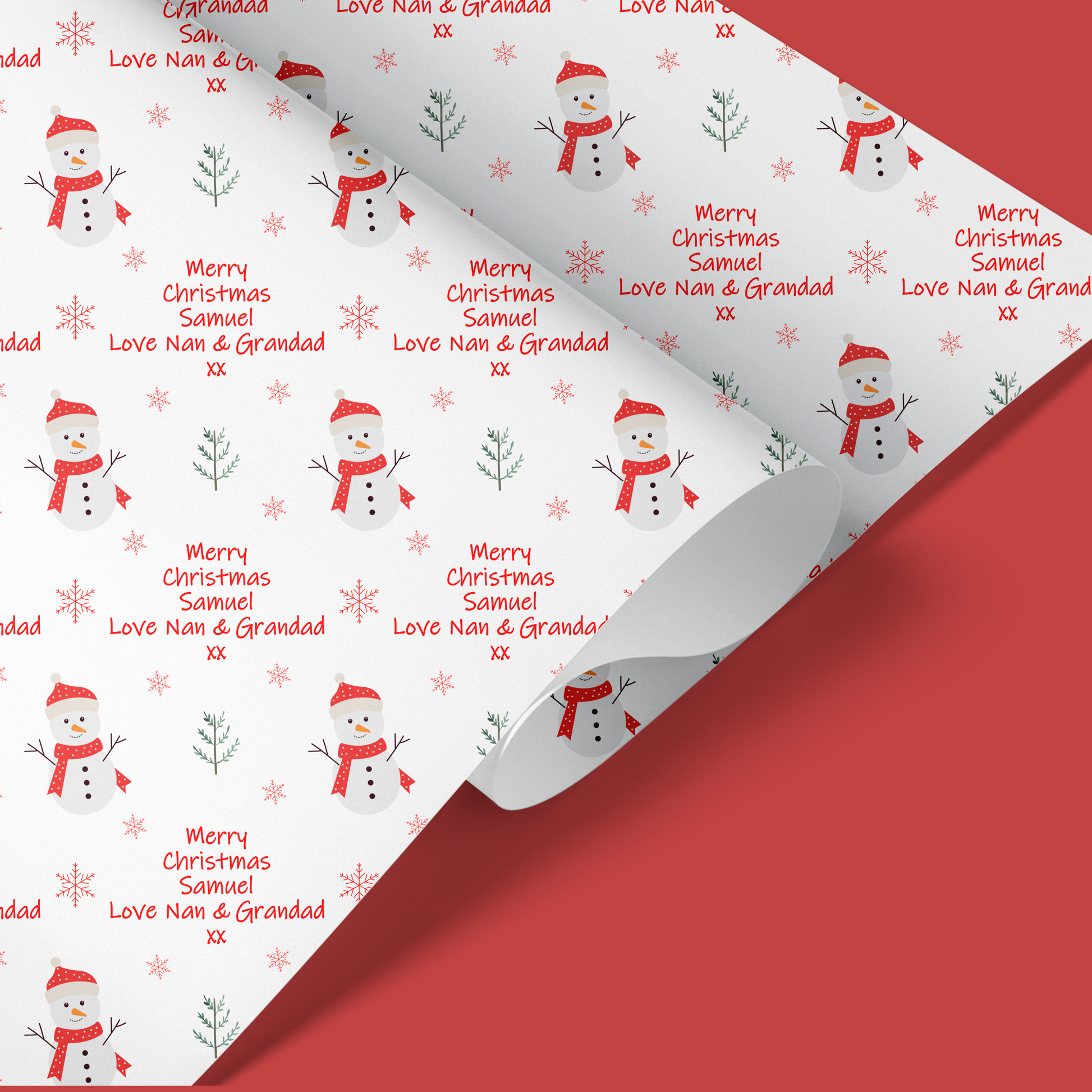 childrens christmas wrapping paper with red snowman design with snowflakes in the background