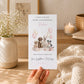 A hand holding a birthday card with a picture of four dogs and balloons, along with a message about a birthday gift.