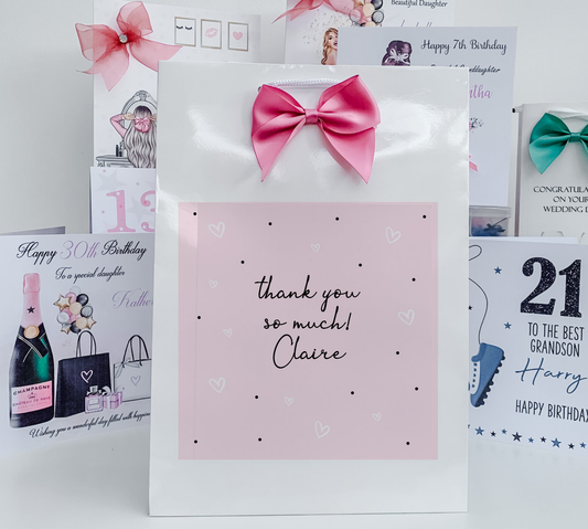 a pink and white greeting card with a pink bow