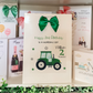 a birthday card with a tractor and a green bow