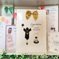 a card with a picture of a girl wearing a graduation outfit and a gold bow